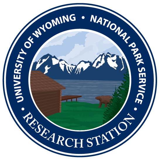 UW-NPS seal with iconic boat dock, a bear, Jackson Lake, and the Tetons